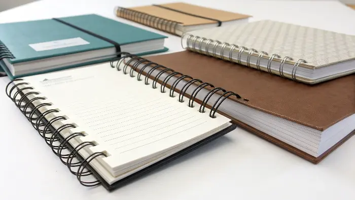 Image showing Wire-O bound notebook next to a lay-flat sewn notebook