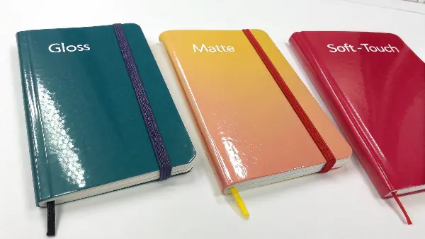 Side-by-side comparison of books with gloss, matte, and soft-touch lamination.