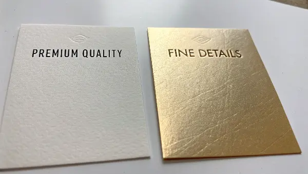 A side-by-side comparison showing the crisp deboss of hot stamping and the flat detail of cold foiling.